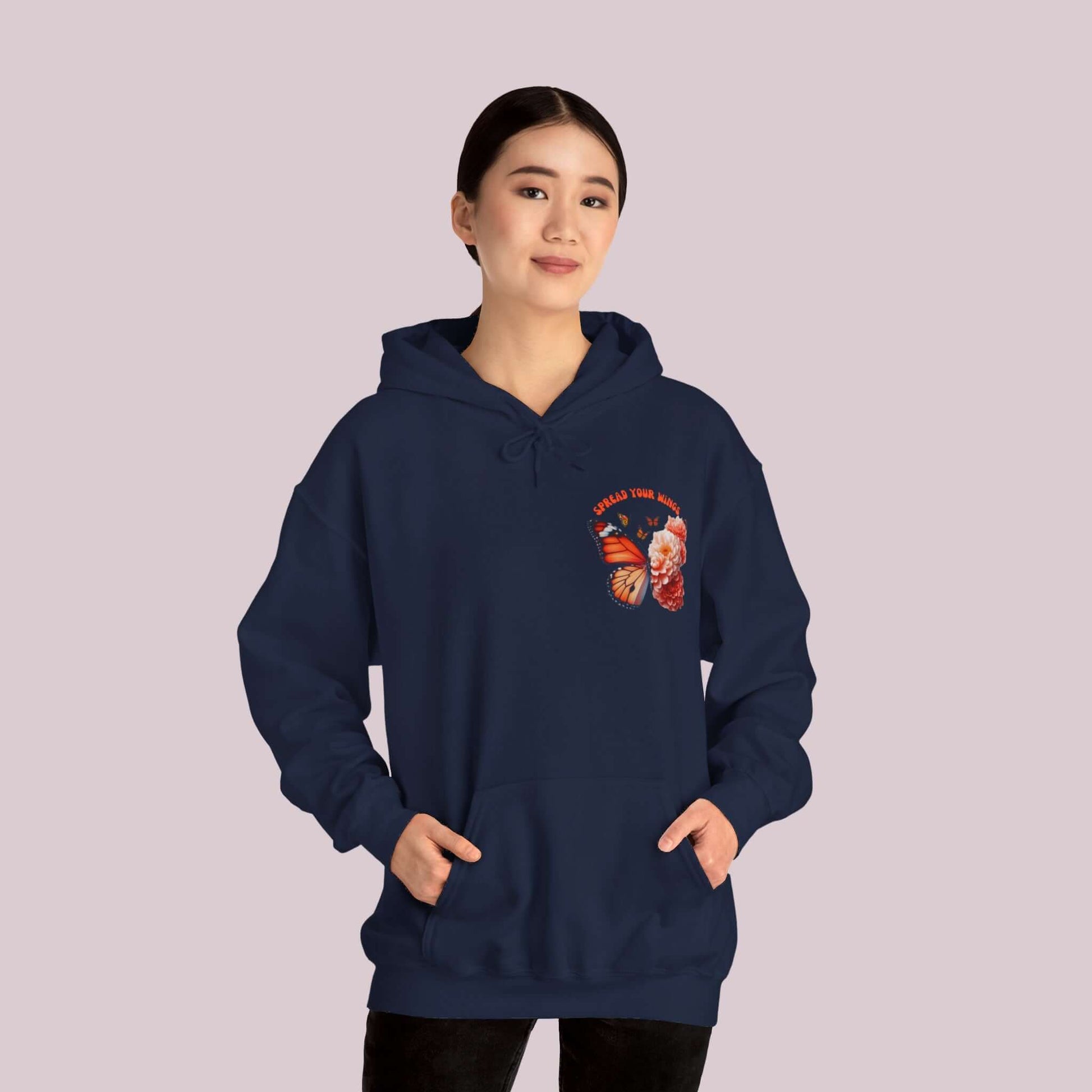 Woman wearing "Spread Your Wings" Butterfly and Flowers Hoodie in navy blue, featuring a soft, high-quality fabric for ultimate comfort and style.