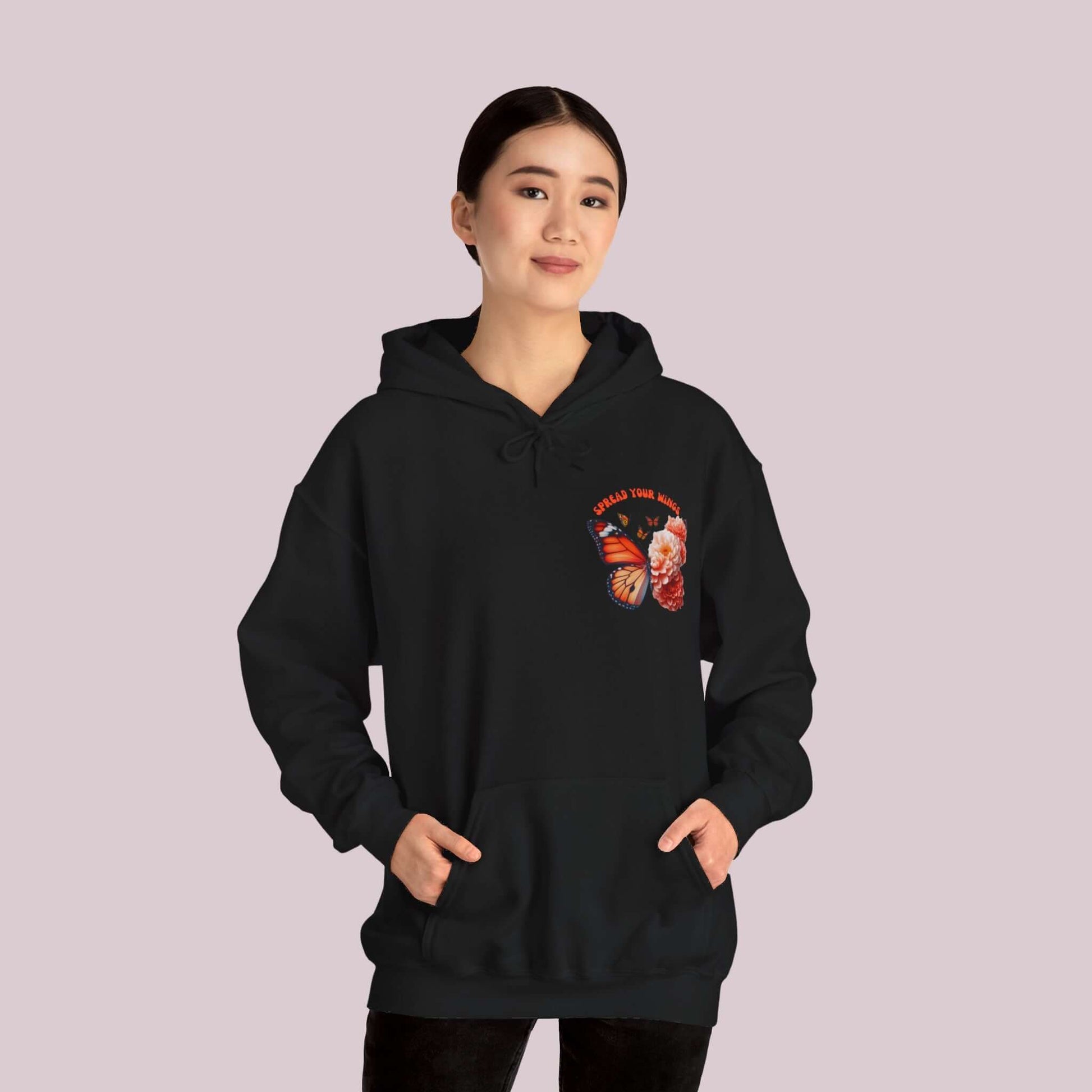 Woman wearing "Spread Your Wings" Butterfly and Flowers Hoodie, showcasing butterfly and flower design.