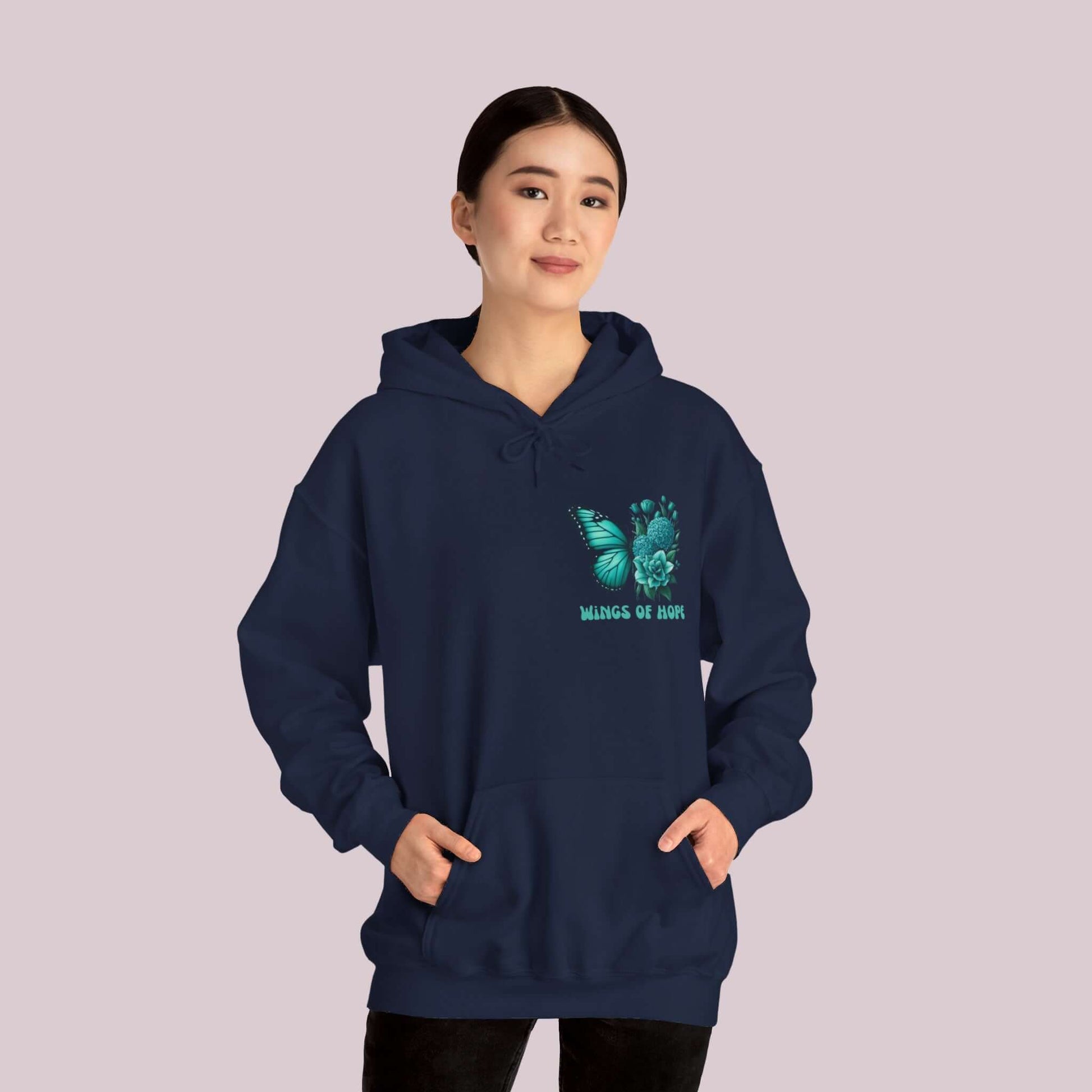 Woman wearing "Wings Of Hope" Butterfly and Flowers Hoodie, navy blue, featuring a butterfly and floral design.