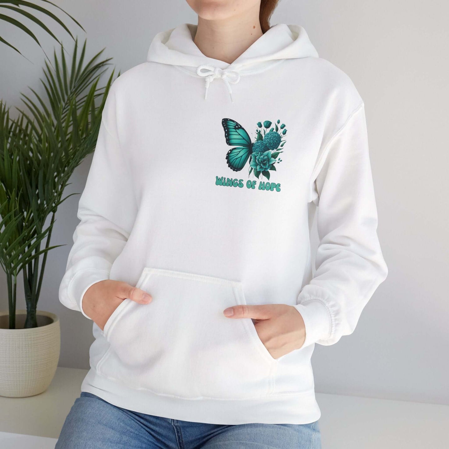 Woman wearing "Wings Of Hope" butterfly and flowers white hoodie, cozy and comfortable high-quality fabric design